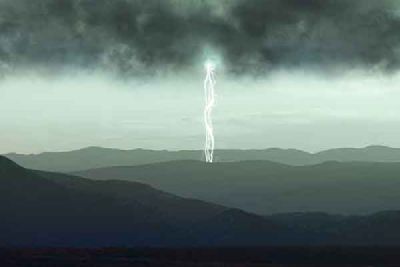 A lightning bolt over hills under a dark storm cloud