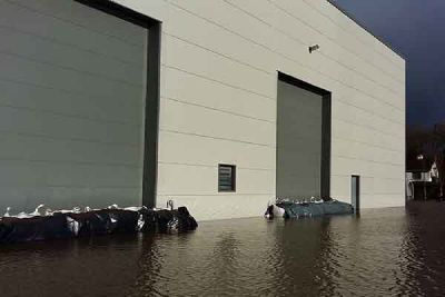 Flood water around the loading doors of a large industrial building