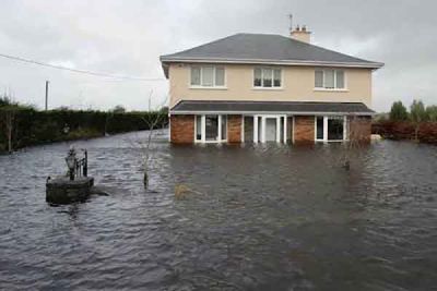 A house standing in flood water on open land